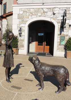 In the plaza of lots of shops was the statue of a girl and her dog playing fetch!